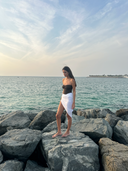 Side profile of the Caletta White 100% Cotton Pareo, styled short to highlight the effortless wrap for resort wear.