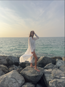 Caletta White 100% Cotton Long Chemise worn open over swimwear on the coast. Timeless resort cover-up.